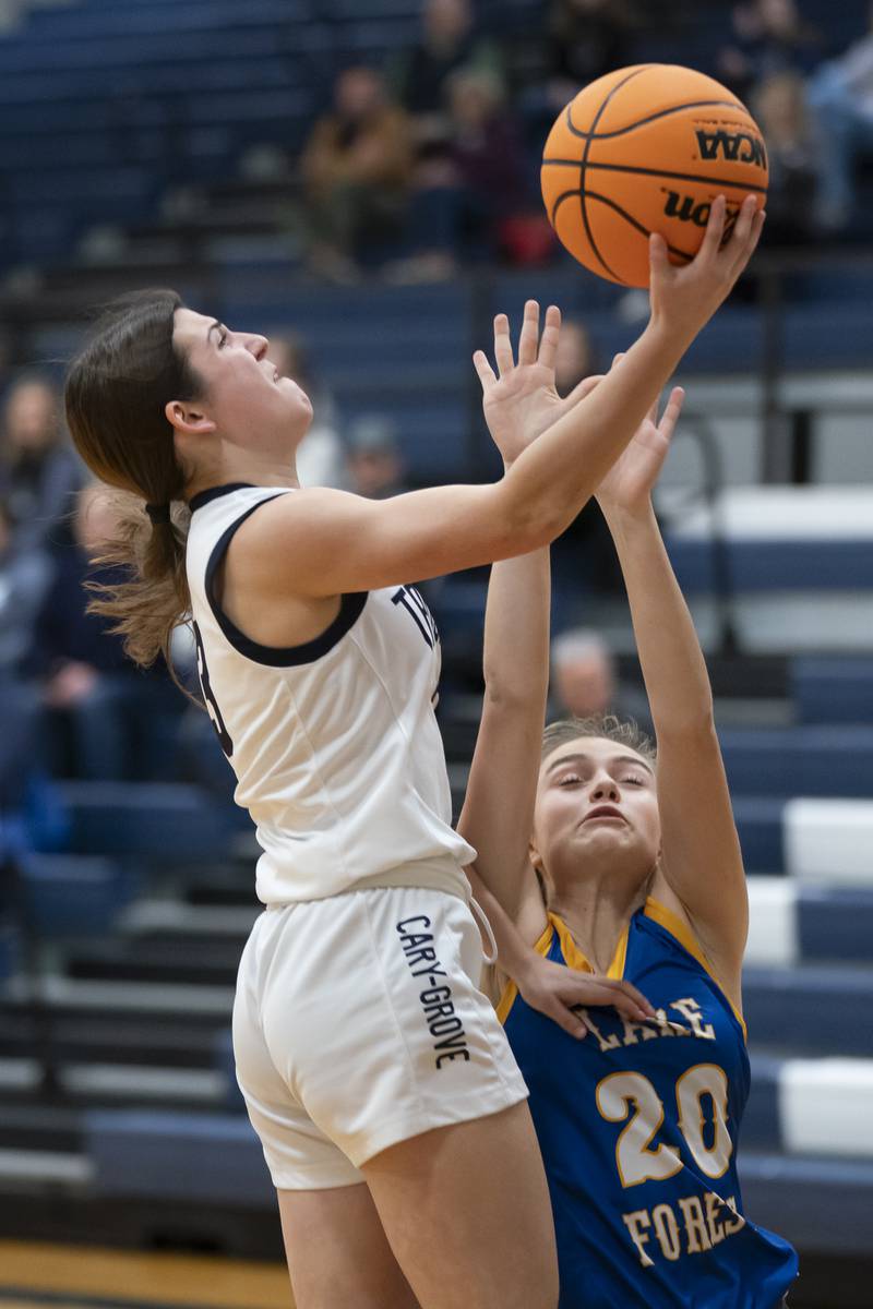 Cary-Grove's Kennedy Manning shoots with pressure from Lake Forest's Charlotte Axus during the Class 3A Cary-Grove Regional Girls Basketball Championship game on Thursday, February 20, 2025 in Cary. Ryan Rayburn for Shaw Local