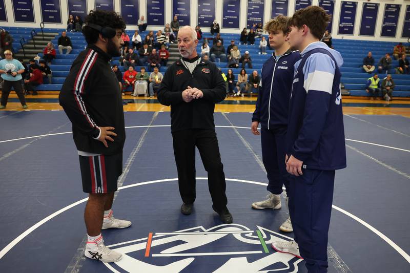 Plainfield North’s Leo Tovar, left to right, Plainfield South’s Matt Janiak and Colin Bickett go over rules with the referee before the start of the Southwest Prairie dual meet on Wednesday, Nov. 29, 2023 in Plainfield.