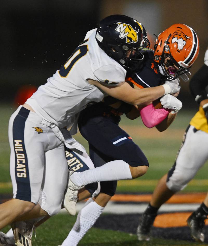 Naperville North’s Charlie Shinkle, right, gets tackled by Neuqua Valley’s Ethan Engler, left, and Rocco Dubiel during a football game played on Friday, Oct. 11, 2024 in Naperville.
