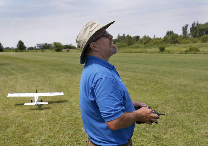 Larry Erbach pilots his plane through a radio control as another plane prepares to take off on Thursday, Aug. 8, 2024. He's with the Chain-O-Lakes Eagles RC Club.