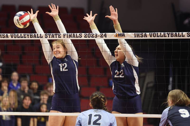 IC Catholic’s Maura Grogan, left, and Jenny Fromelt goes for the block against Mater Dei in the Class 2A Volleyball Championship match on Saturday, Nov. 11, 2023 in Normal.