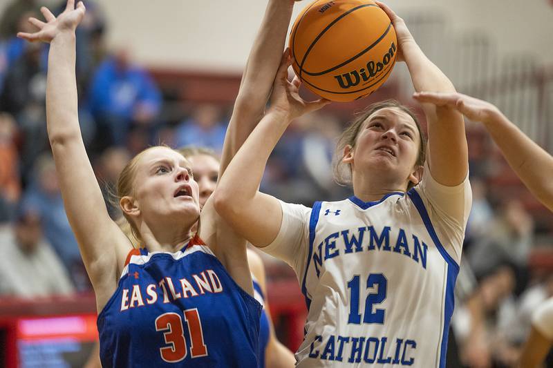 Newman’s Lucy Oetting works below the basket against Eastland’s Violet Diehl Tuesday, Feb. 18, 2025, during the Class 1A girls basketball regional at Forreston.