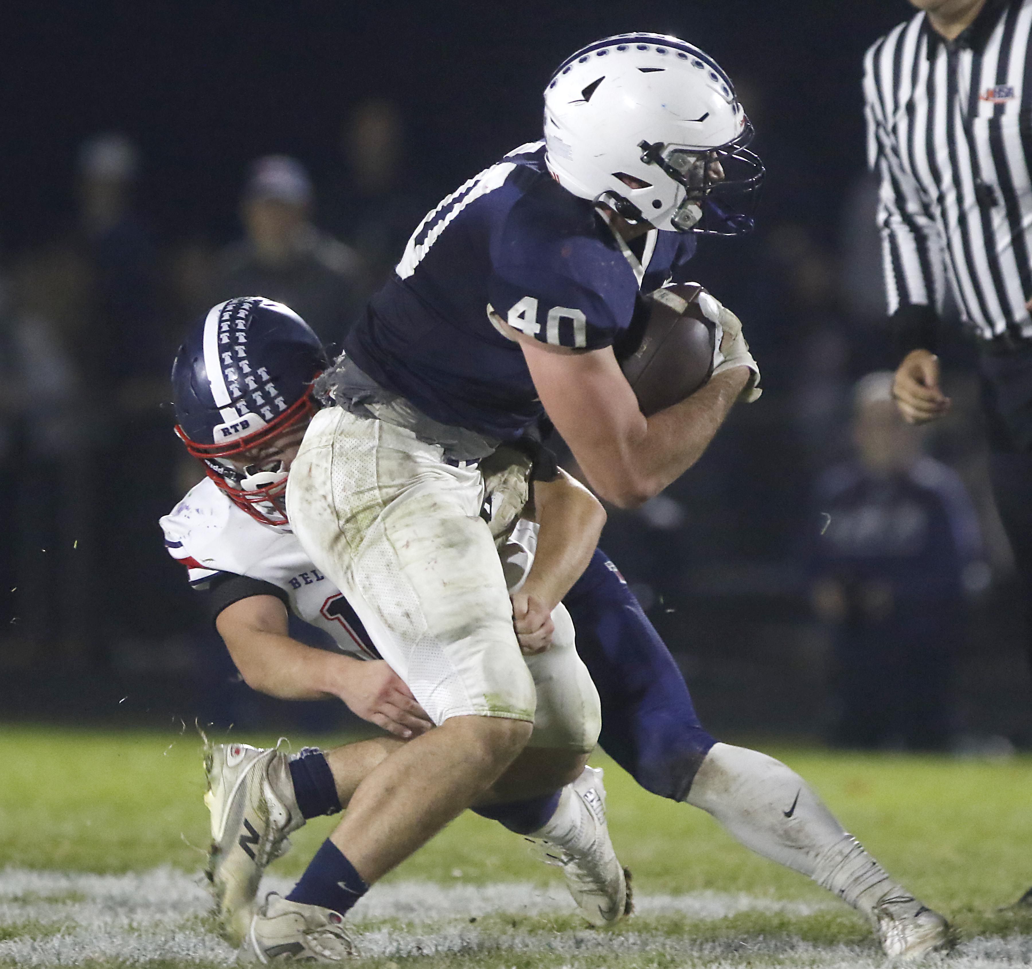 Cary-Grove's Logan Abrams is tackled by Belvidere North's Noah Rooney during an IHSA Class 5A quarterfinal playoff football game against Belvidere North on Friday, November 14, 2025, at Cary-Grove High School, in Cary.
