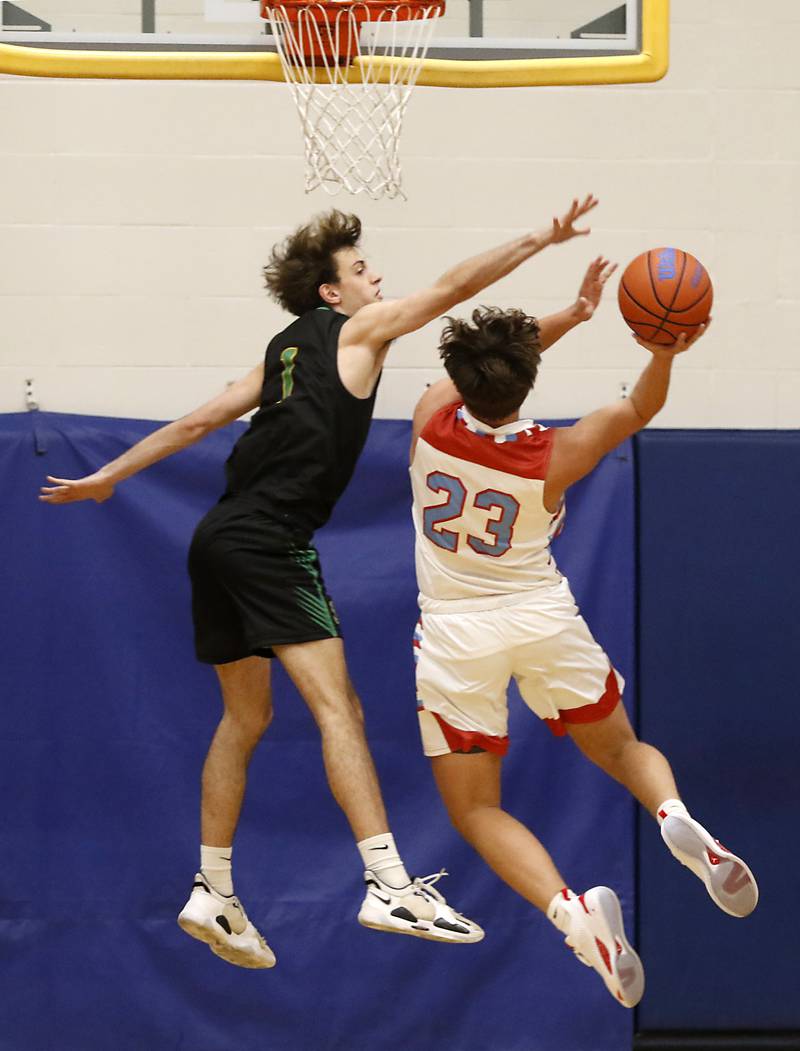 Crystal Lake South's Zachary Peltz tries to block the shot of Marian Central's Cale McThenia during the Johnsburg Boys Basketball Thanksgiving Tournament Monday, Nov. 21, 2022, between Crystal Lake South and Marian Central at Johnsburg High School.