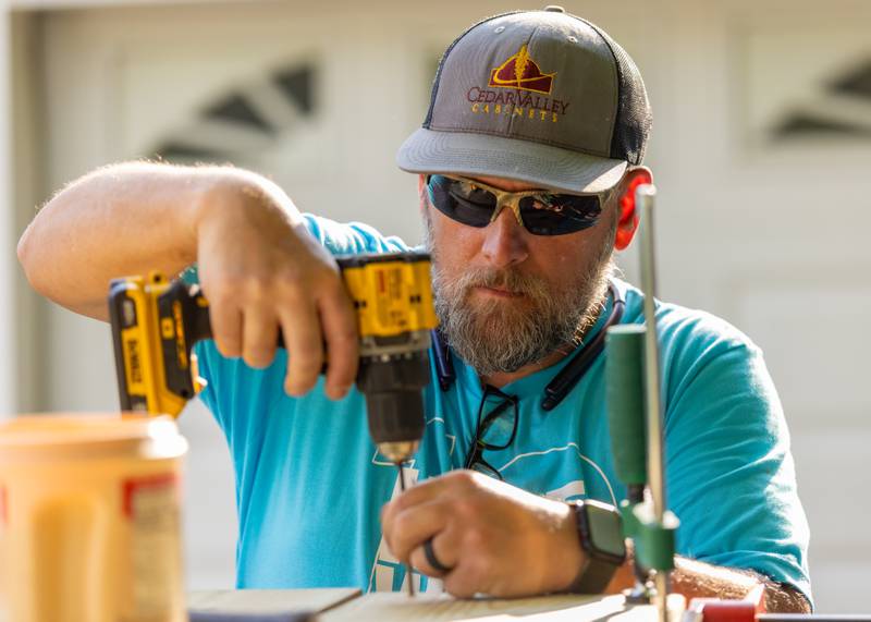 Jeff Locke drills a screw in to secure a board as part of a wheel chair accessibility ramp at a private residence on June 6, 2025 in Peru.