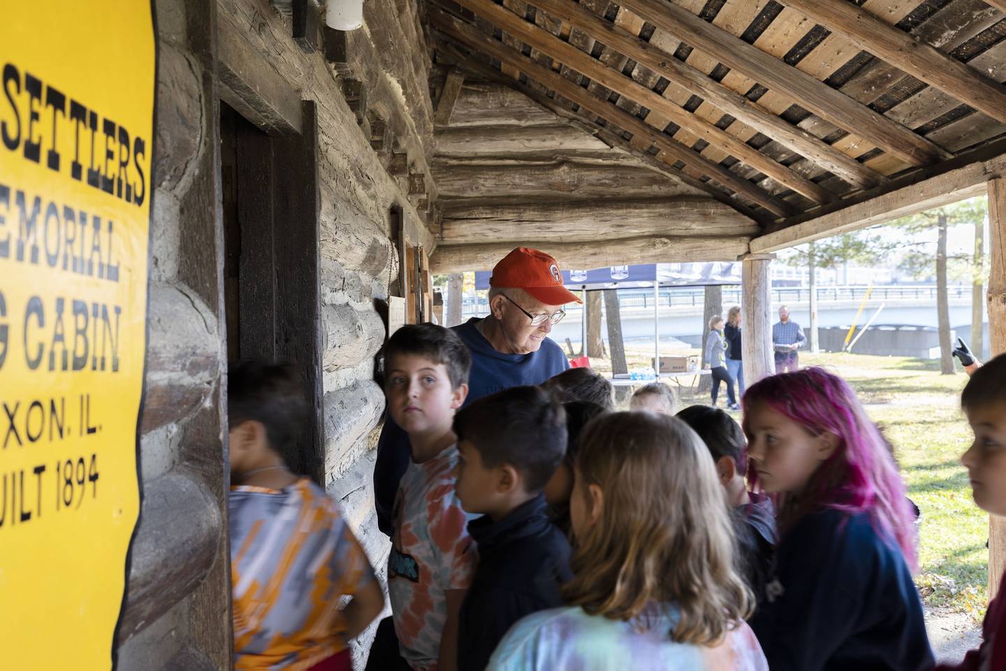 Lee County Historical and Genealogical Society volunteer Gary Michel leads students in the Old Settlers memorial cabin situated at Presidents Park in Dixon. Students also visited the spot where founder John Dixon first set up his homestead, the Dixon Historic Theatre and other buildings in the  downtown.