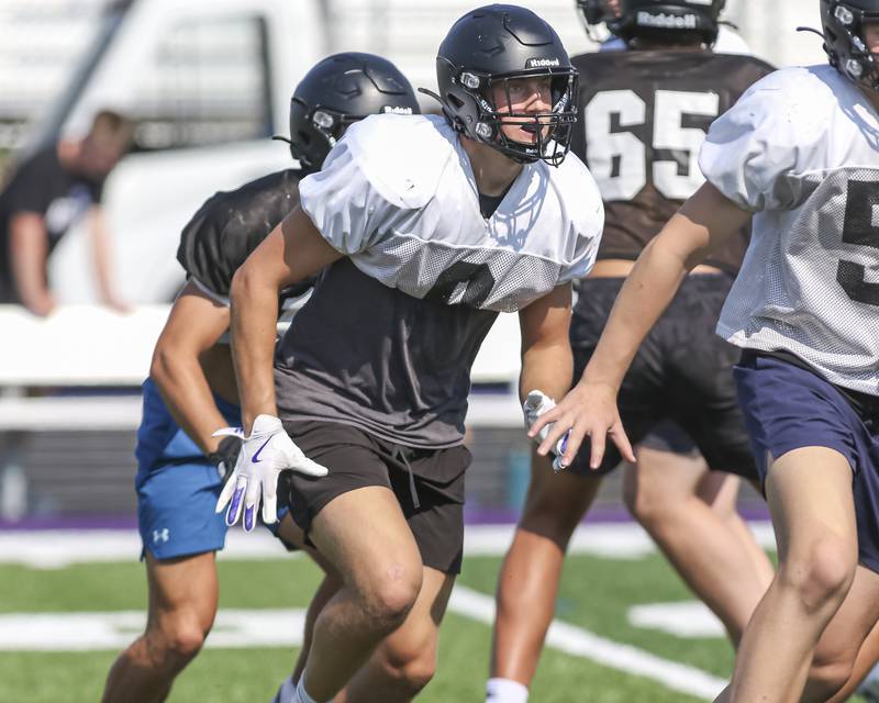 Will Vala lead blocks on a running play walk through at Downers Grove North High School football practice, Thursday, Aug 14, 2025  in Downers Grove.