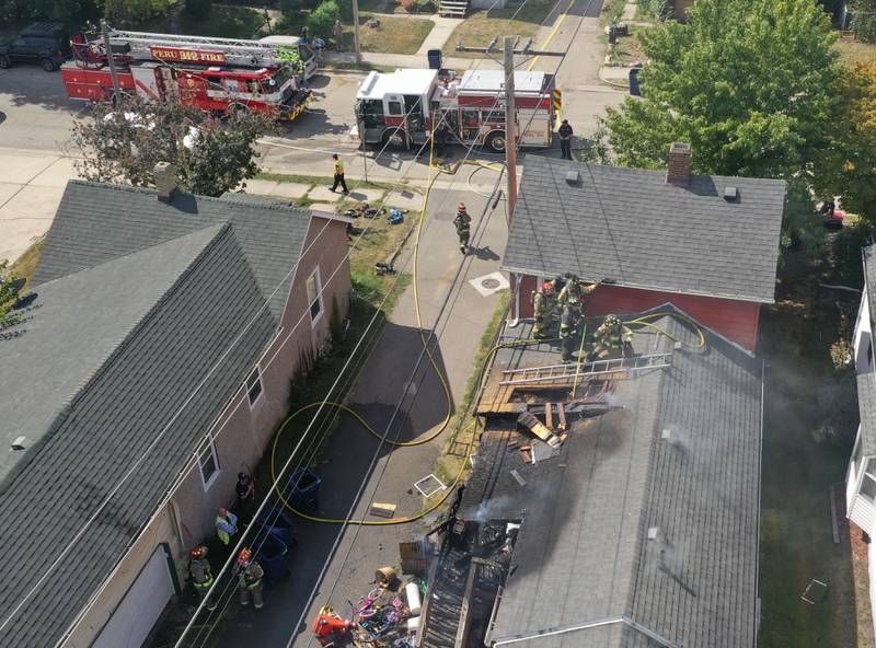 La Salle and Peru firefighters work the scene of a structure fire as smoke emits from the attic from a home in the 300 block of Crosat Street on Thursday, Sept. 19, 2024 in La Salle. The fire happened shortly after 12:30p.m.
