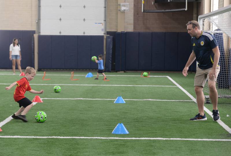 Nathan Larson of Glen Ellyn practices his soccer goals with his dad Jeff during the Glen Ellyn Park District unplug from technology event held Saturday July 13, 2024.