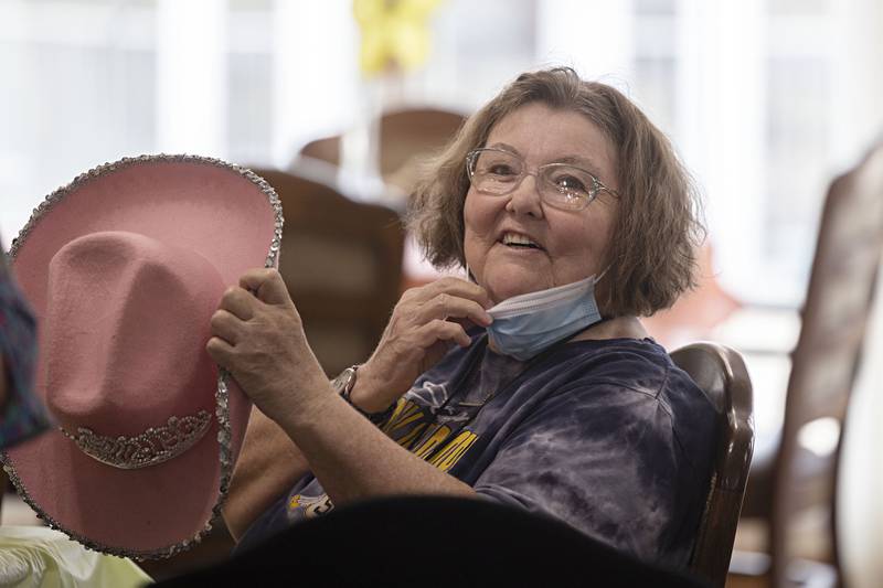 Janis Locke dons a fancy hat Friday, March 31, 2023 at Heritage Woods in Sterling for the tea party celebration.