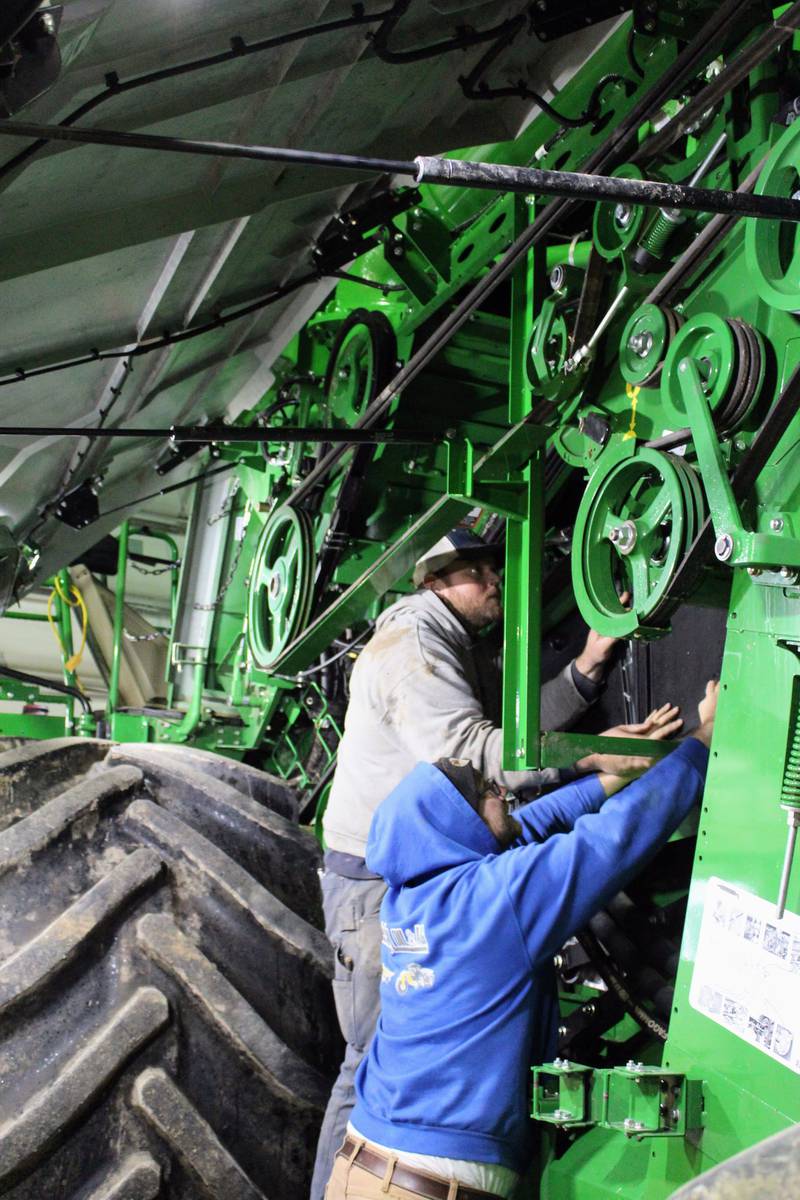 Correy (left) and Mitchel Rahn check for worn parts on their combine following the completion of harvest on their northern Illinois farm. Warm, dry weather contributed to an early harvest this year which they finished on Oct. 29.