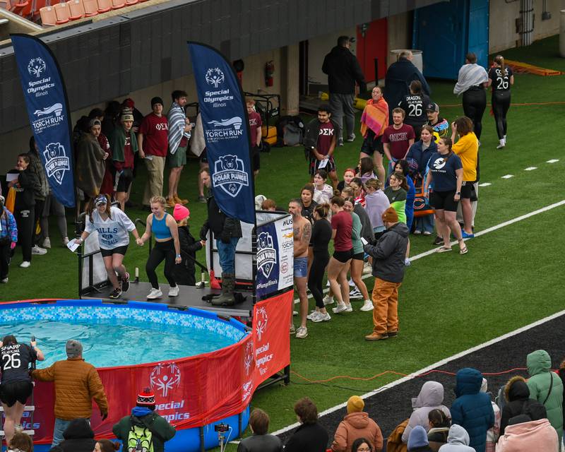Participants wait to take the plunge as others jump in while spectators watch pool side on Saturday Feb. 21, 2026, during the Polar Plunge event held at Huskie Stadium.