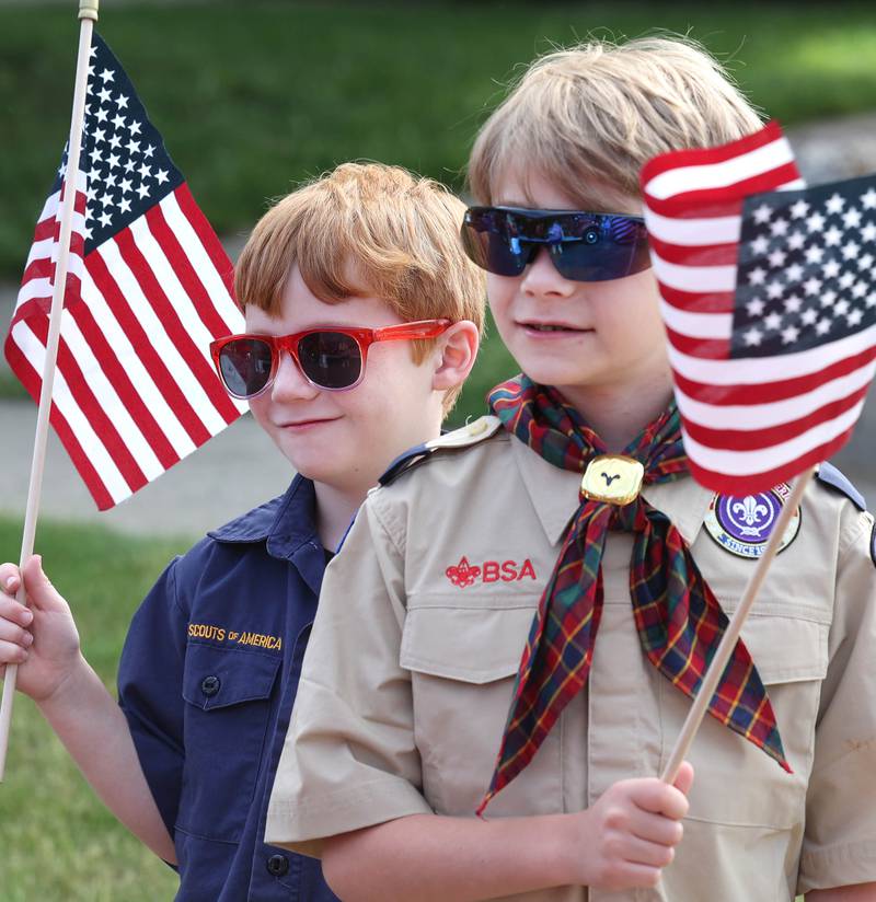Cub Scouts Harvey Robertson, 7, (left) and his brother Henry, 10, wave flags Monday, May 29, 2023, as they get ready to march in the DeKalb Memorial Day parade.