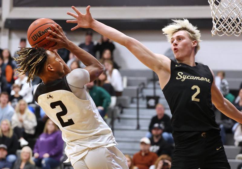 Kaneland's Isaiah Gipson scores over Sycamore's Aidan Wyzard during their game Friday, Jan. 5, 2024, at Kaneland High School in Maple Park.