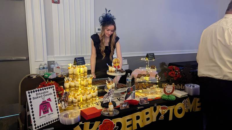 Savannah Splitt  of Bolingbrook places sweet treats on the Biteable Baked Goods table at the Shorewood HUGS chocolate ball on Saturday, February 1, 2025, in Joliet.