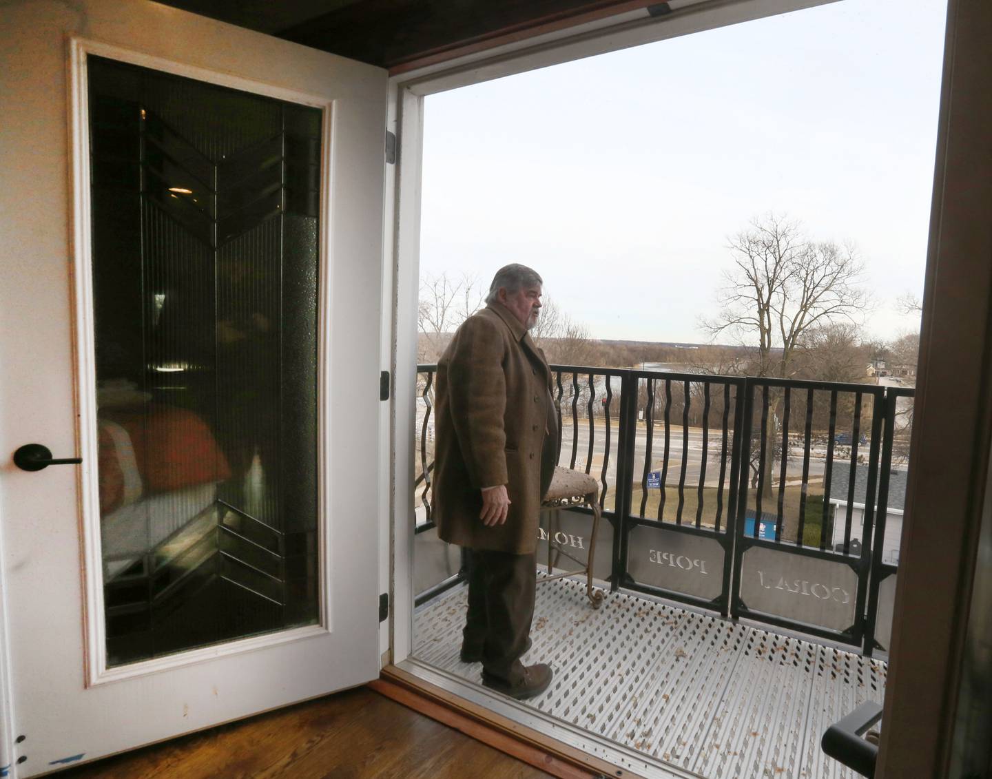 Larry Mitchell, owner of The Cora J. Pope Home, looks out the balcony over the Illinois River on Tuesday, Jan. 20, 2026 in Ottawa. The home located at 116 W. Prospect Ave., is for sale for the third-time ever. It was built in 1902.