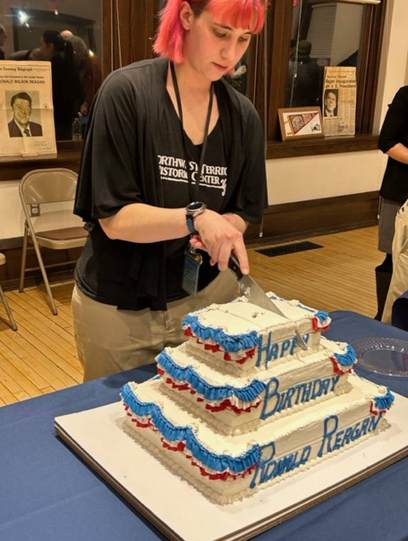 Gwen Moore cuts into a birthday cake Tuesday, Feb. 6, 2024, at the Northwest Territory Historic Center in Dixon during a celebration marking the 113th anniversary of President Ronald Reagan's birth.