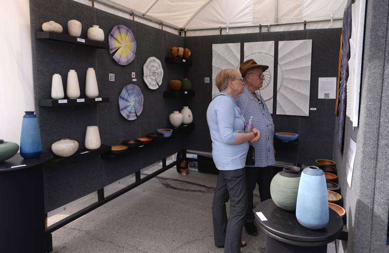 Cindy Drapac and Daniel Hirsch of Clarendon Hills look at some of the art work  during the West End Arts Festival in LaGrange Saturday, Sept. 21, 2024.