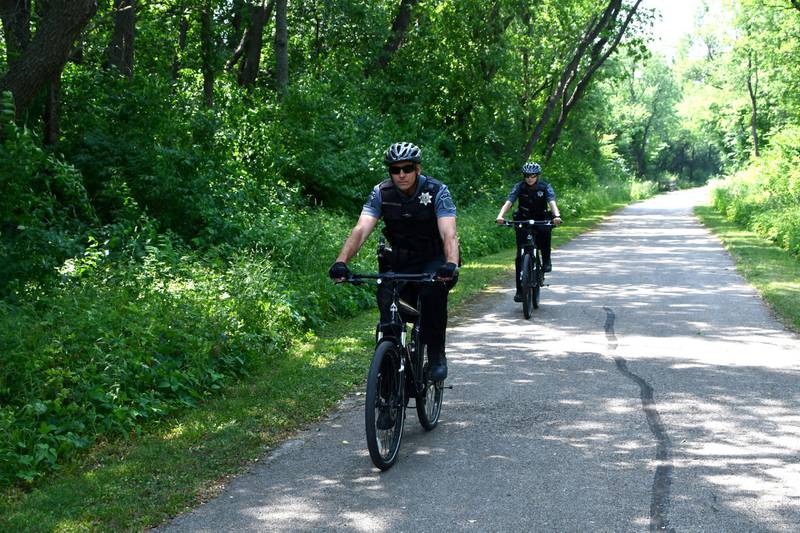 Forest Preserve District of Will County Police Sergeant Dan Olszewski and officer Caitlin Mosier ride bikes on the Wauponsee Glacial Trail in preparation for summer patrols throughout the district.