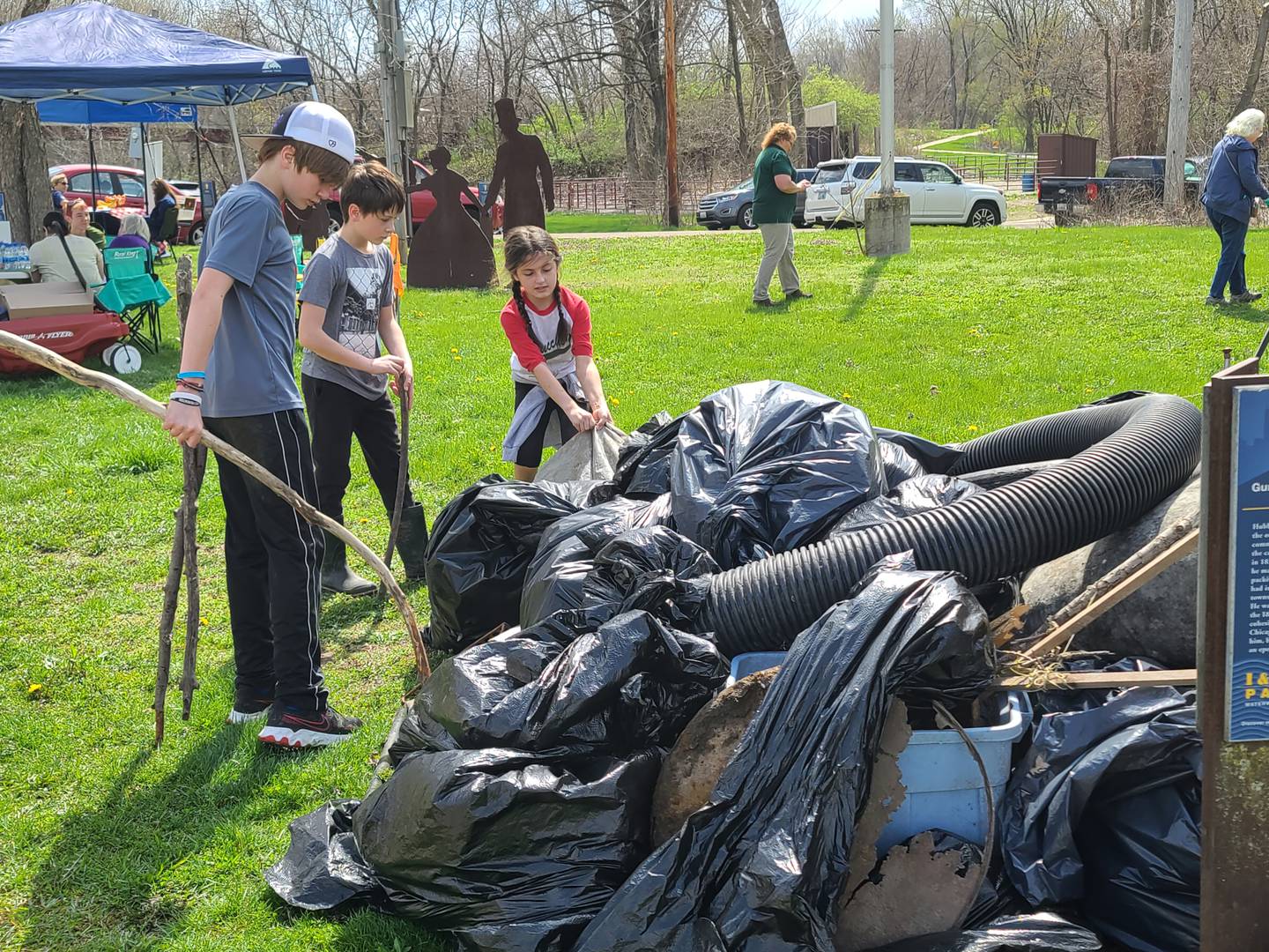 Volunteers Kash Tomsha, Gianni Verucchi and Cecelia Verucchi participate in an Earth Day Cleanup on Saturday at Lock 14 Shelter along the Illinois-Michigan Canal near La Salle. The event was organized by  the Perfectly Flawed Foundation.