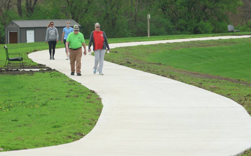 Dave and Brenda Janecka of Utica, walk the new path on Thursday, April 16, 2026 at Baker Lake in Peru. The project is now complete and the park is back open to the public. Construction work began last October and included a 10-foot-wide concrete path, with secondary concrete paths also added, connecting the new parking lot near Lighted Way to the parking lot, playground, and shelter on the west side of Baker Lake. The new path is 2 feet than the current one.