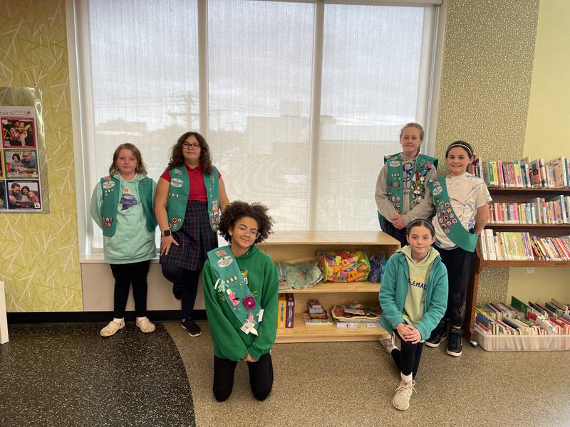 Members of Girl Scout Troop 466 of DeKalb deliver a bookshelf to the DeKalb Public Library, shown April 17, 2023.