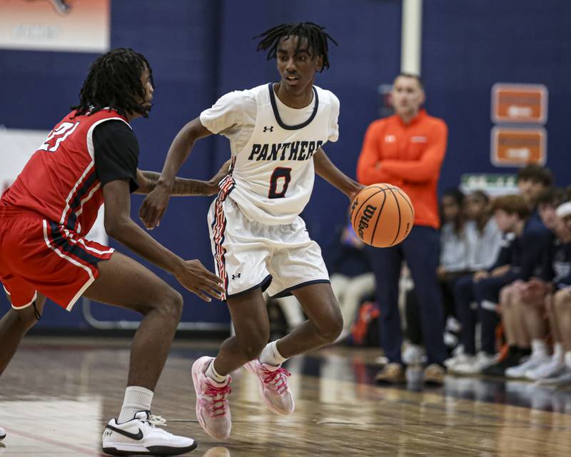 Oswego's Jaxson Woods (0) makes a move on West Aurora's Amon Greene (21) during their basketball game between West Aurora at Oswego Monday, Nov 24, 2025 in Oswego.