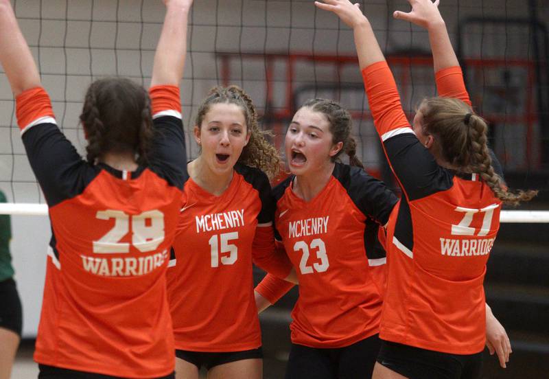 McHenry’s Sophie Zieba, center left , Mollie Hobson, center right, celebrate a point against Crystal Lake South in varsity volleyball at McHenry Tuesday night. The host Warriors fell in three sets to the Gators.