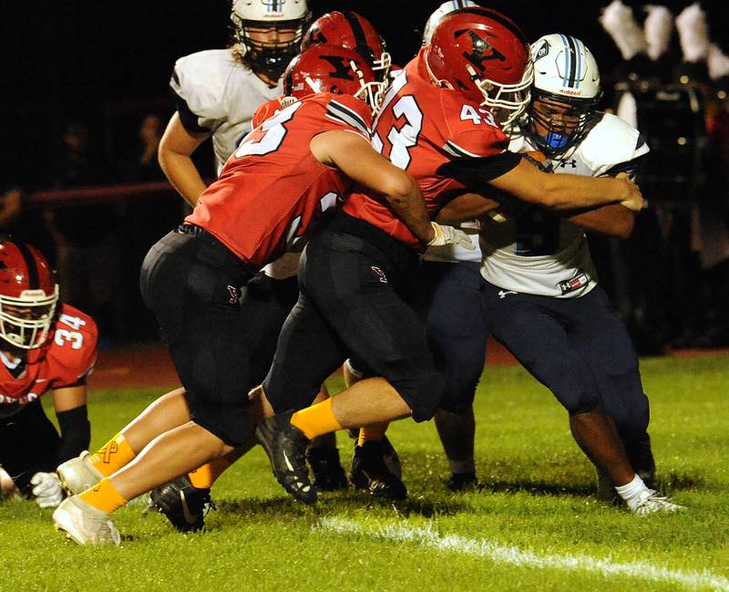 Plainfield South running back Brian Stanton (right) got just enough forward progress to avoid a safety, as Yorkville defenders Ben Alvarez (left) and Hunter Janeczko (43) stuff him at the line during a varsity football game at Yorkville High School on Friday.