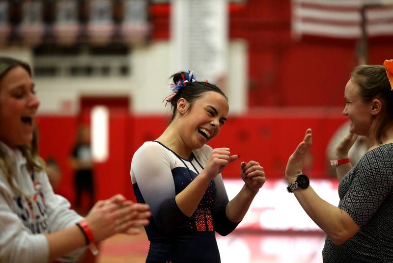 Oswego Co-op’s Ava Sullivan celebrates with her coaches after competing on the balance beam during the Hinsdale Central Sectional on Monday, Feb. 10, 2025 in Hinsdale.
