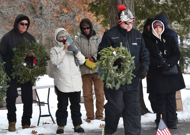 Veteran Jim Lauer carries a wreath to be placed for the USAF near the Civil War Veteran's Memorial at the Daysville Cemetery during the Wreaths Across America program Saturday, Dec. 13, 2025.