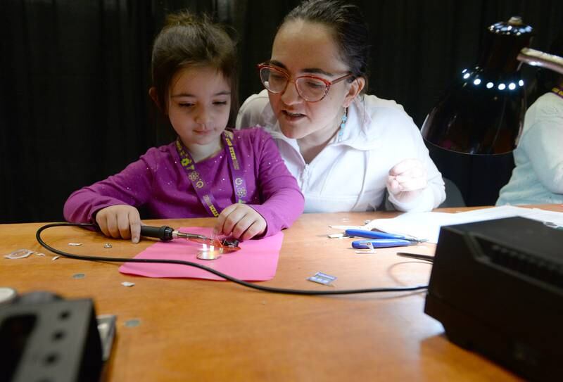 Freya Verson and her mom Alissa of Lombard make a Boy Scout pendant during the STEMCON event on Saturday April 26, 2025 at the College of DuPage in Glen Ellyn.