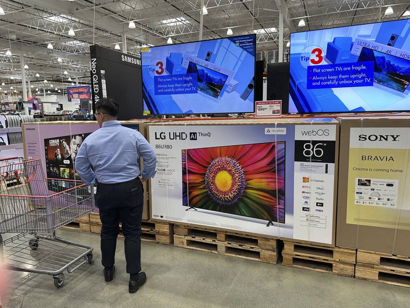 FILE - A shopper considers large-screen televisions on display in a Costco warehouse Oct. 3, 2024, in Timnath, Colo. (AP Photo/David Zalubowski, File)