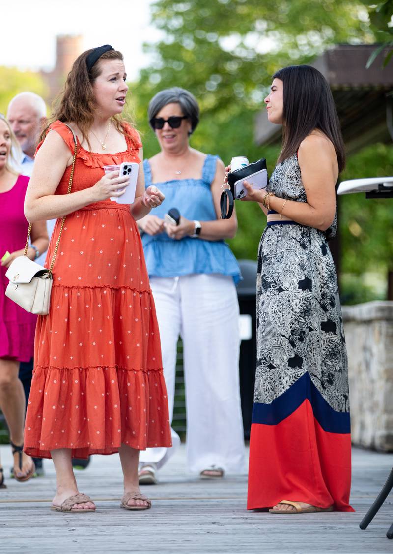 Callie Moran and Nina Maturo of Glen Ellyn converse during Thirsty Thursday on the Deck at the Lake Ellyn Boathouse in Glen Ellyn on July 20, 2023.