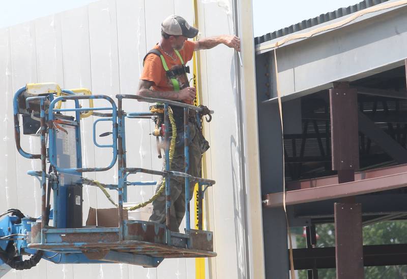 A worker builds an exterior wall at the future Aldi grocery store on Tuesday, Aug. 13, 2025 at the intersection of Backbone Road and North Main Street in Princeton. Crews are beginning to build the exterior walls this week. The 20,000 square-foot store could be open by Thanksgiving.