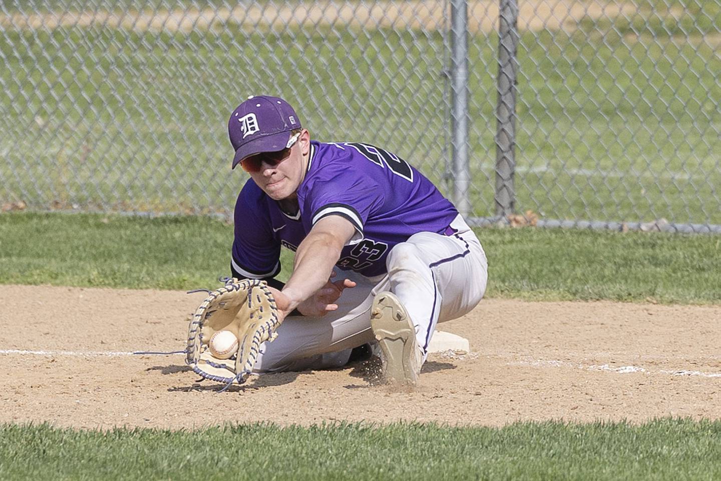 Dixon’s Quentin Seggebruch scoops a low throw at first for an out against Sterling Tuesday, May 16, 2023.