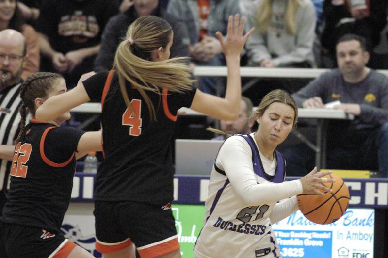 Dixon's Reese Dambman passes the ball around two Byron defenders. The Dixon Duchesses hosted Byron in girls basketball Saturday, Jan. 25, 2025