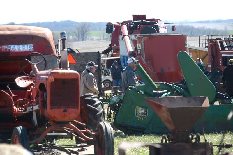 Two visitors to the Hazelhurst Annual Spring Consignment Auction walk between rows of farm machinery on Saturday, April 6, 2024. The annual event is held each year on a farm along Milledgeville Road, between Polo and Milledgeville.