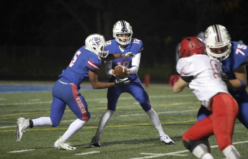 Glenbard South's Nick Plaso hands the ball off to Kylen Henderson during their home game against Glenbard East Oct.12.