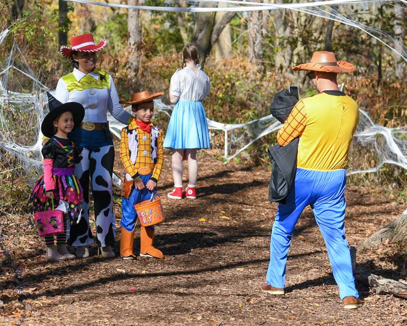 Eddie Kerxhalli takes a photo of his family Alda, Matteo, 7, and Zoe, 5, of Lombard on Saaturday Oct. 26, 2024, during the Boo Bash trail event held at Ackerman Park in Glen Ellyn.