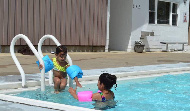 ReyLynn Chapa, 9, helps her 3-year-old sister, Anaya Chapa, into the Polo pool on May 28. The outdoor pool, located at Keator Park, opened on May 27 for the 2022 season.