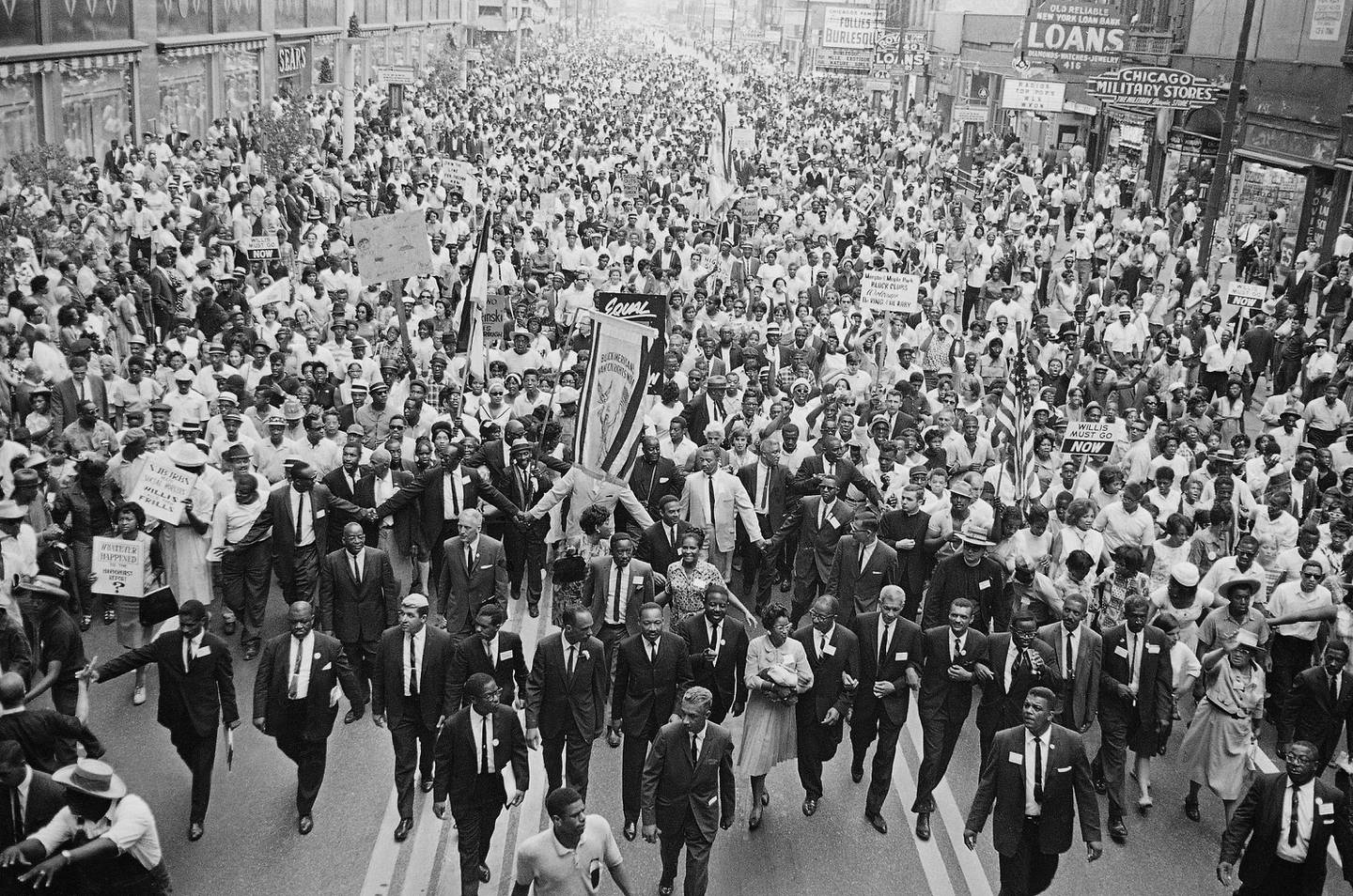 Rev. Martin Luther King Jr. (center foreground) walks in vanguard of crowd estimated at more than 10,000 persons who gathered in downtown Chicago, July 26, 1965 to protest segregation in the city's schools.