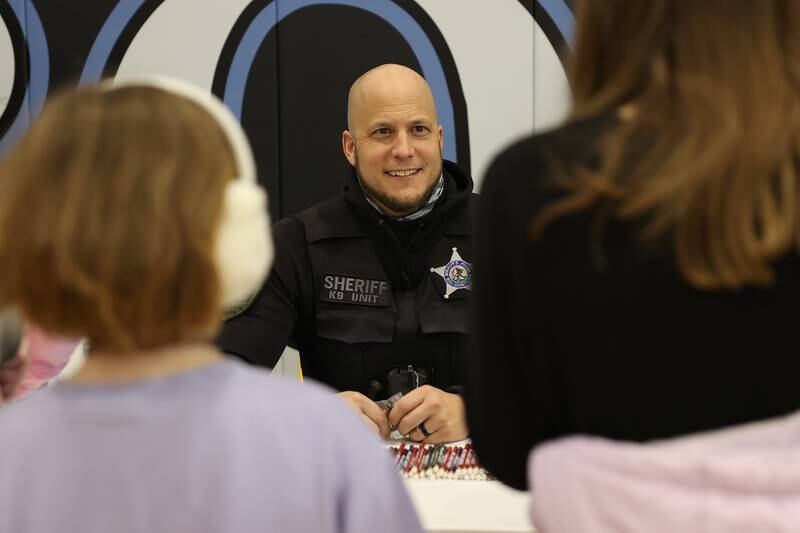 Deputy Gabriel Son chats with a group of kids at the Will County Sheriff’s Office vendor at the Will County Executive 2024 Kids’ Fair at Troy Middle School in Plainfield on Monday, Feb. 19, 2024.