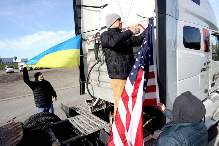 Viktor Zholkevych z Hoffman Estates umieszcza amerykańską flagę na ciężarówce, gdy kierowcy zbierają się w sobotni poranek we wschodnim Dundee, aby rozpocząć wiec protestacyjny ciężarówek Deblockade Mariupol, którego gospodarzem jest Help Ukraine Foundation LTD, aby zwrócić uwagę na blokadę Mariupol.