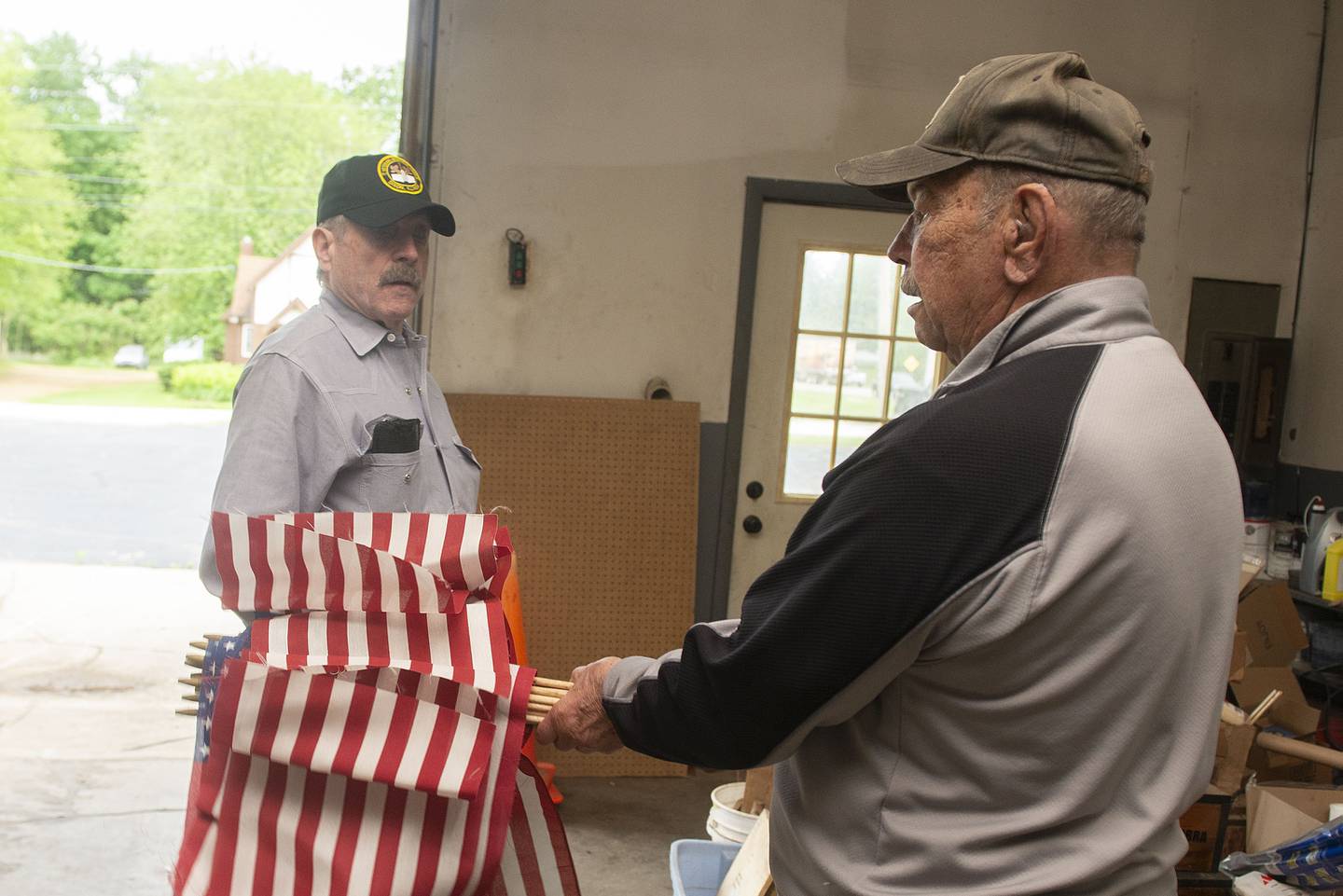Hudson (left) and Al Wikoff prepare flags to be unfurled later in the day in recognition of Memorial Day.