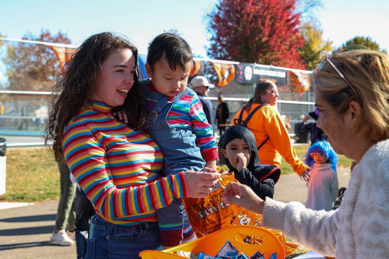 Family picks candy out of bucket at the annual trick or treat at Washington park on Saturday, October 26, 2024 in Peru.