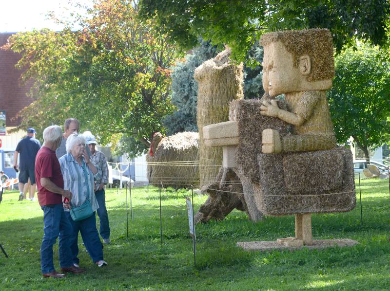 Visitors to Strawfest check out the four new creations before voting on Saturday, Aug. 23, 2025 in Mt. Morris.