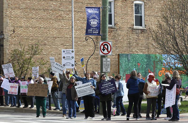 Protesters line U.S. Route 12 in Richmond to protest their discontent with President Donald Trump and his administration's policies on Saturday, April 19, 2025. Over 100, people took part in the Richmond protest. A second rally was held in Harvard later in the day.