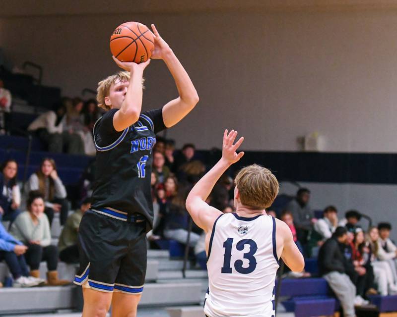 St. Charles North's Parker Reinke, left, makes a basket while being defended by West Chicago's Caleb Giannokis (13) during the second quarter on Tuesday Nov. 28, 2023, held at West Chicago Community High School.