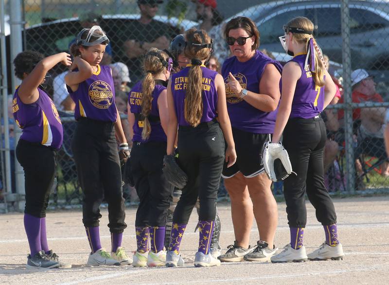 Warriors head coach Kari Hilton meets with her team on the mound during the Ottawa Girls Fastpitch Association 11U City Championship on Wednesday July 2, 2025 at Peck Park in Ottawa.